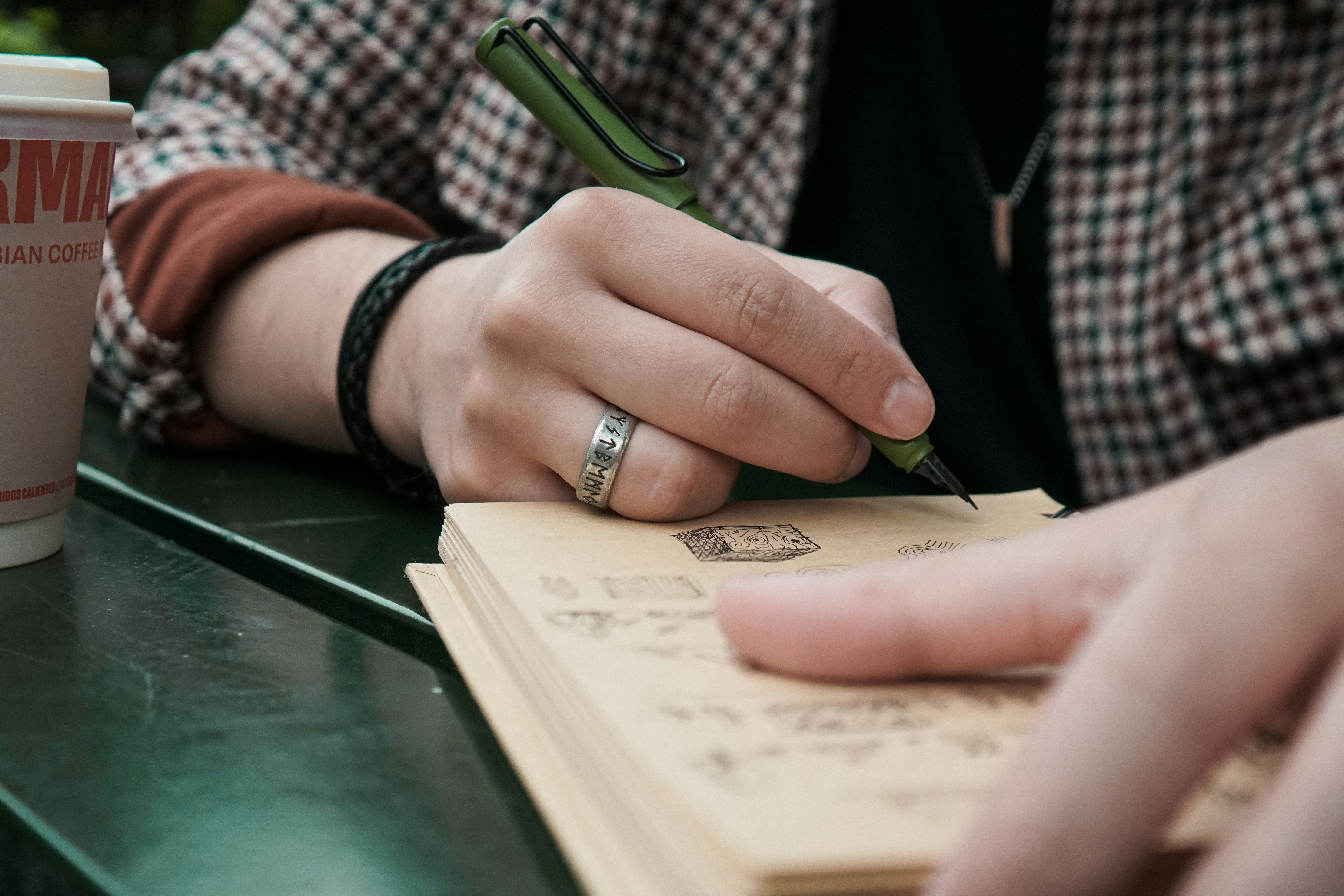 Person taking creative notes in a notebook, getting ready to do work